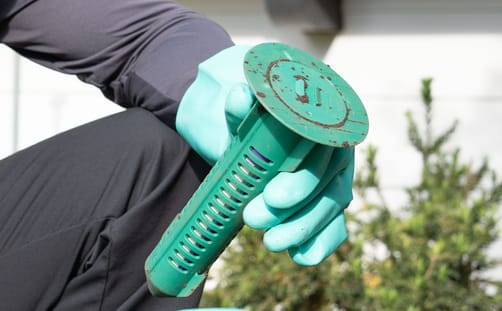 Hawx technician inspecting a Sentricon® bait station in the ground